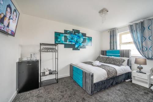 a bedroom with a blue and white bed and a window at *RC27R* For your relaxed & Cosy stay + Parking in Kirkstall