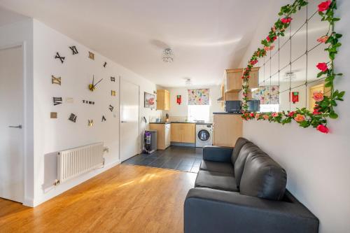 ein Wohnzimmer mit einem Sofa und einer Küche in der Unterkunft *RC27R* For your relaxed & Cosy stay + Parking in Kirkstall