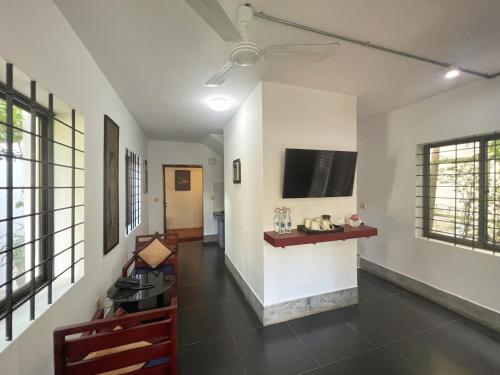 a hallway with white walls and a tv on a wall at The Bliss Angkor in Siem Reap