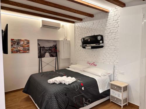 a bedroom with a bed and a tv on a brick wall at CA.FOSCARI in Milan
