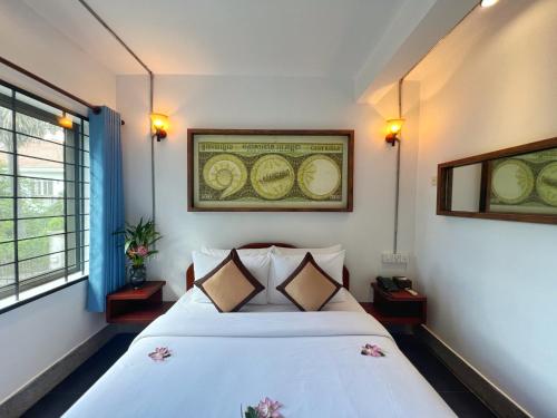 a bedroom with a white bed in a room at The Bliss Angkor in Siem Reap