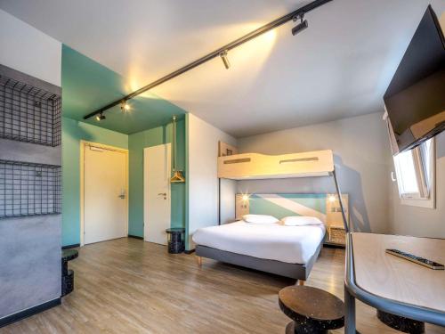 1 dormitorio con 1 cama y escritorio en una habitación en ibis budget Forbach Centre, en Forbach