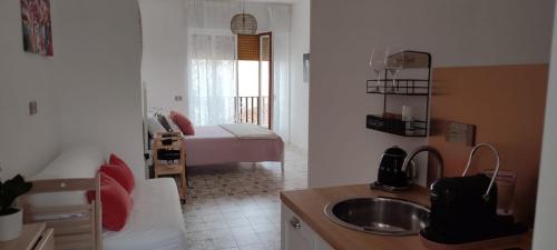 a small kitchen with a sink and a bedroom at Edahouse in Salerno