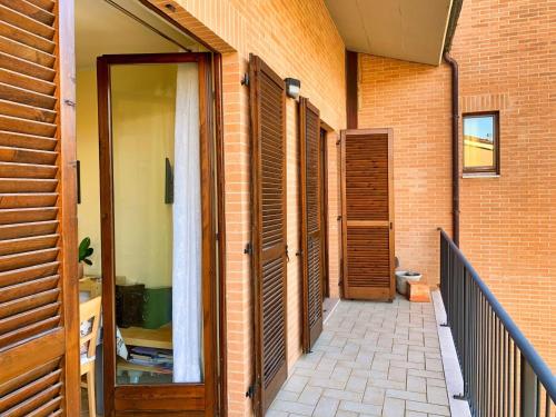 a hallway of a brick building with wooden doors at La casa di Lory in Sarnano