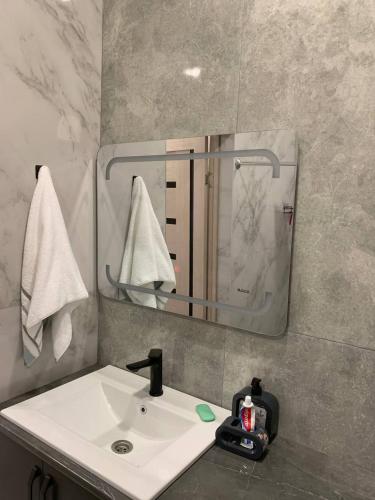 een badkamer met een witte wastafel en een spiegel bij Agarak House 