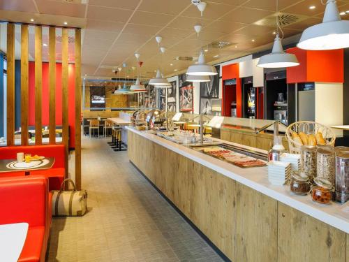 a fast food restaurant with a long counter at Ibis Hamburg City in Hamburg