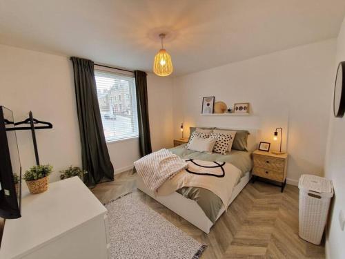 a bedroom with a bed and a large window at Koselig Properties in Lerwick