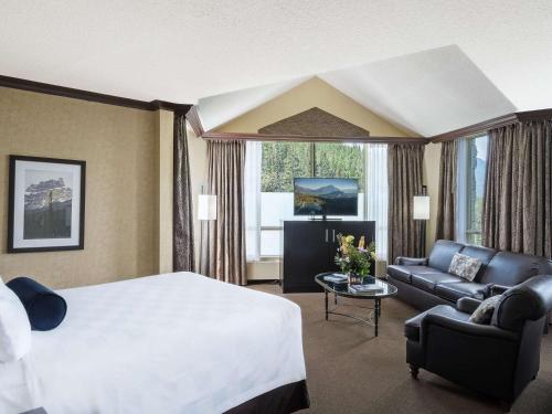 a hotel room with a bed and a couch at The Rimrock Resort Hotel Banff in Banff