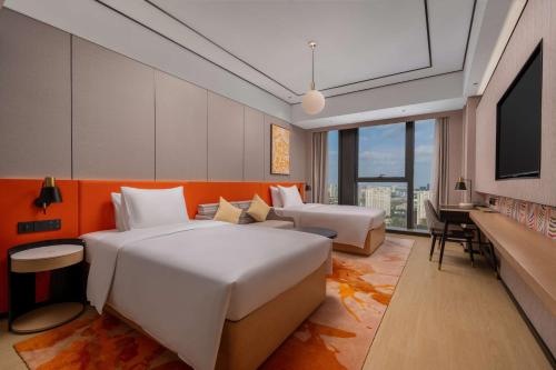 une chambre d'hôtel avec deux lits et une télévision à écran plat dans l'établissement Hilton Garden Inn Nantong Haohe Scenic Area, à Nantong