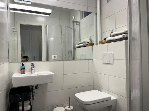 uma casa de banho branca com um lavatório e um WC em Stadtstudio Saarlouis em Saarlouis