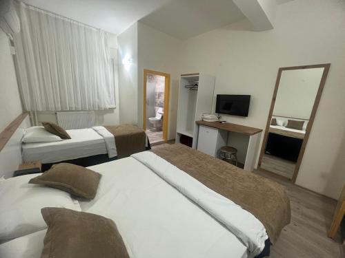 ディヤルバクルにあるKöprücü Hotelのベッド2台と鏡が備わるホテルルームです。