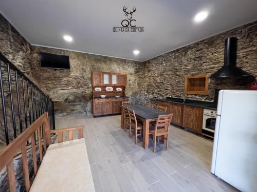 a kitchen with a table and chairs and a refrigerator at Quinta da Coitada - Alojamento Local in Soutelo do Douro