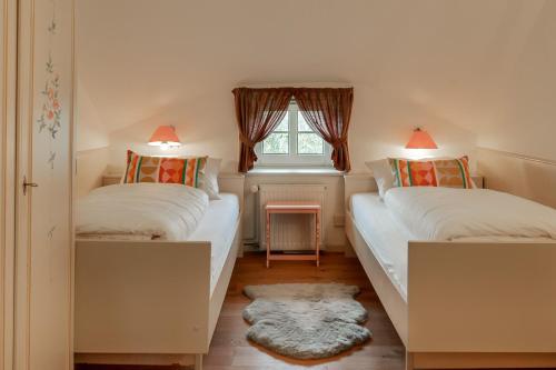 una piccola camera con due letti e una finestra di Im Lütten a Braderup