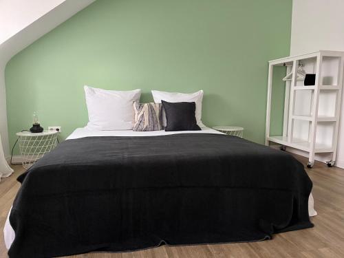 a bedroom with a large black bed with pillows at Stadtstudio Saarlouis in Saarlouis