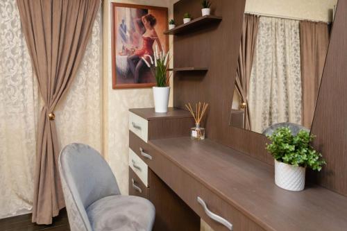 a room with a vanity with two chairs and a mirror at Exclusive Apartment in Giurgiu