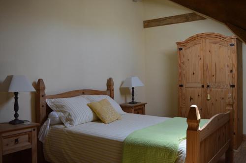 a bedroom with a bed and a wooden cabinet at Le Domaine des Crouquets in Jayac