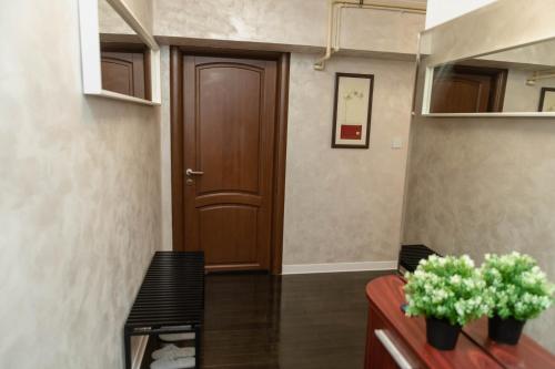 a hallway with a door and a bench and flowers at Exclusive Apartment in Giurgiu