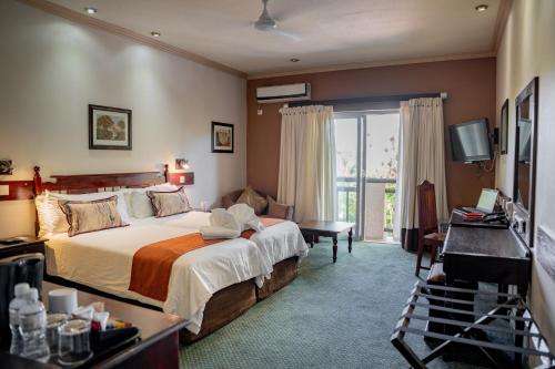 a hotel room with a bed and a balcony at Diggers Inn in Francistown