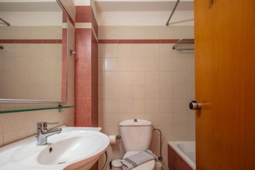 a bathroom with a sink and a toilet and a tub at Aristea Hotel in Rethymno Town