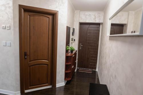 a hallway with a wooden door and a staircase at Exclusive Apartment in Giurgiu