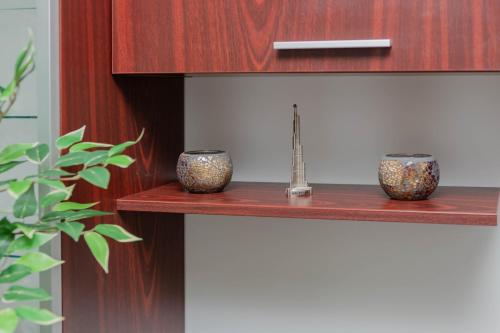 two vases are sitting on a wooden shelf at Exclusive Apartment in Giurgiu