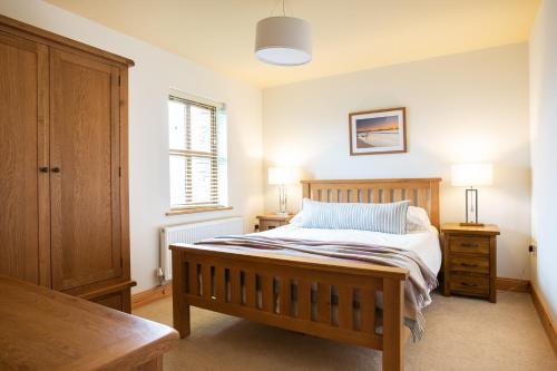 een slaapkamer met een bed met 2 nachtkastjes en 2 lampen bij Donegal Boardwalk Resort in Carrigart