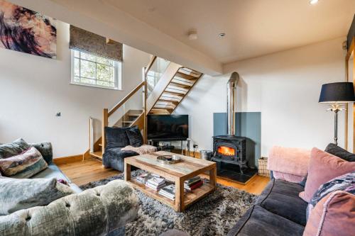 a living room with couches and a wood stove at Host & Stay - The Chapel in Thornham in Thornham