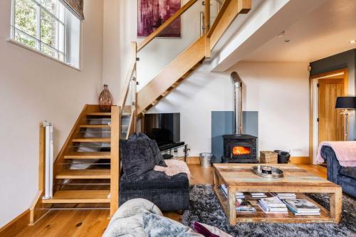 a living room with a staircase and a fireplace at Host & Stay - The Chapel in Thornham in Thornham
