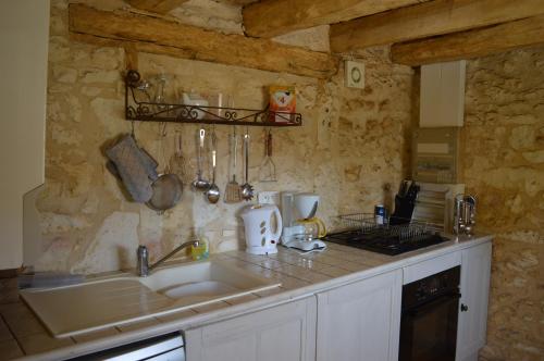 une cuisine avec un évier et un plan de travail dans l'établissement Le Domaine des Crouquets Sarlat, à Jayac