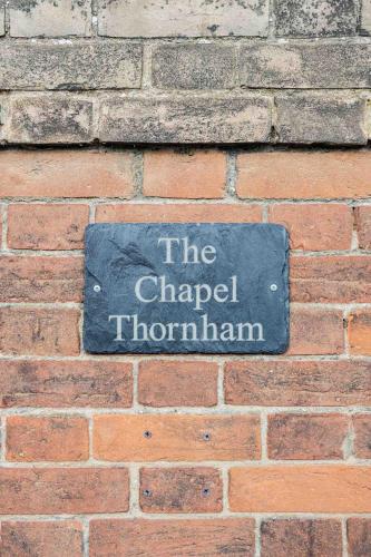 a sign on the side of a brick wall at Host & Stay - The Chapel in Thornham in Thornham