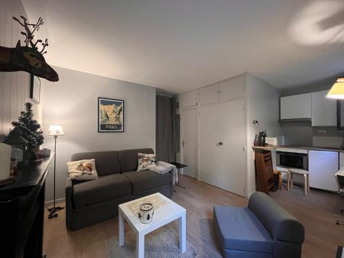 una sala de estar con un sofá y una mesa en Studio rénové au pied des pistes, en Font-Romeu