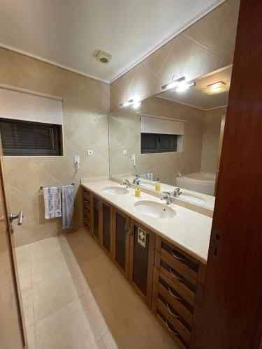 baño con lavabo y espejo grande en Casa Da Estrada Velha, en Medonha