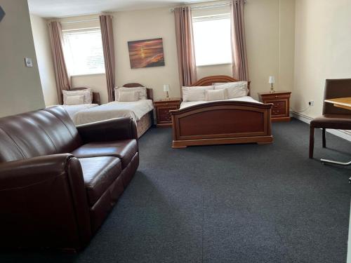 ein Wohnzimmer mit 2 Betten und einem Sofa in der Unterkunft The Goodlife Guesthouse in Harwich