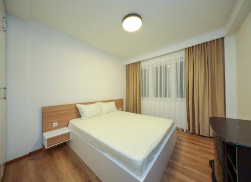 a bedroom with a white bed and a window at Apartment Alpi in Peje