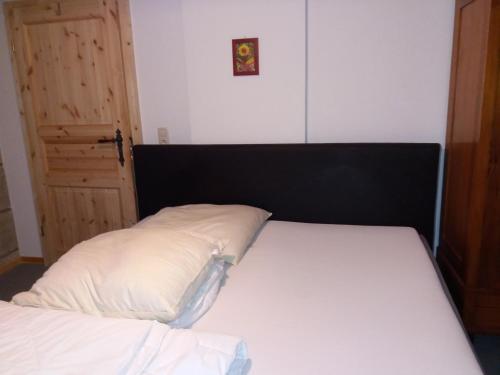 1 cama con cabecero negro y almohada blanca en Ferienwohnung Meier, en Gumperda
