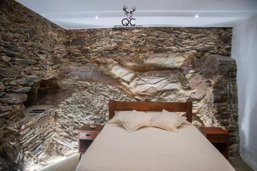Soutelo do Douro的住宿－Quinta da Coitada - Alojamento Local，一间卧室设有石墙和床