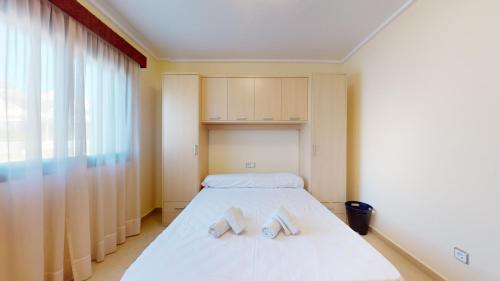 een slaapkamer met een bed met twee handdoeken erop bij Quiet and Sunny apartment with swimming pool in Ciudad Quesada