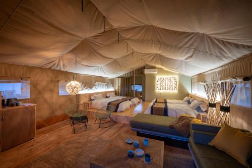 a bedroom with two beds and a large tent at RISE BEACH Okumatsushima in Higashimatsushima