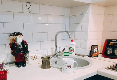 a kitchen sink with a santa figurine on the counter at Vake Residence close to Park Mziuri in Tbilisi City