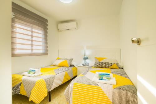 2 camas individuales en una habitación con ventana en Apartamento luminoso, en Sevilla