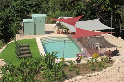a swimming pool in a yard with chairs and a table at Boutique Tropical Retreat, Sleeps 10, Perfect for Friends and Fams in Sámara