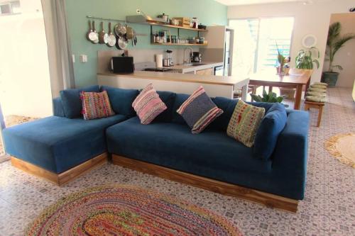 a blue couch with pillows in a living room at Boutique Tropical Retreat, Sleeps 10, Perfect for Friends and Fams in Sámara