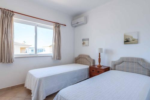 Un dormitorio con dos camas y una ventana. en Villa Sofy, en Galé