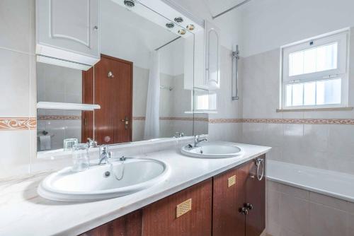 Un baño con dos lavabos y un espejo grande. en Villa Sofy, en Galé