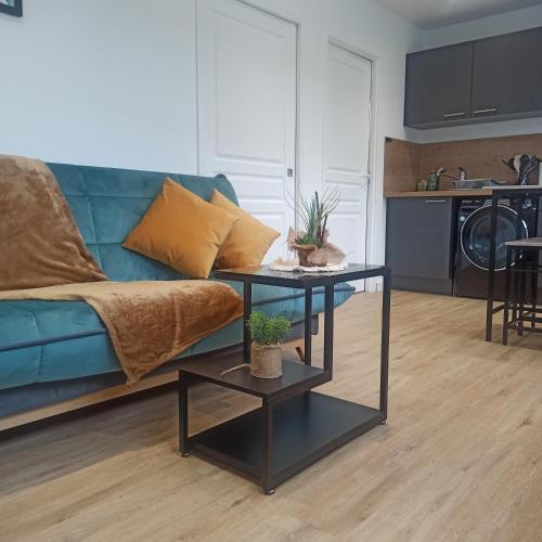 un salon avec un canapé bleu et deux tables dans l'établissement L'étape Da estrela-Nid douillet-Vernon Giverny, à Vernon