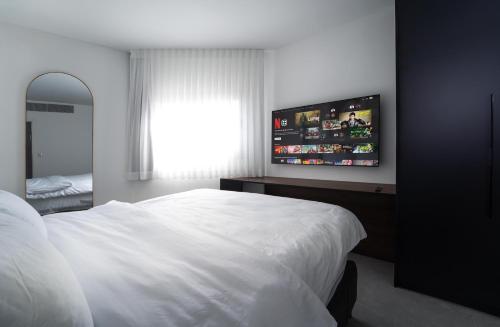 a bedroom with a white bed and a window at premium suite sea side in Eilat