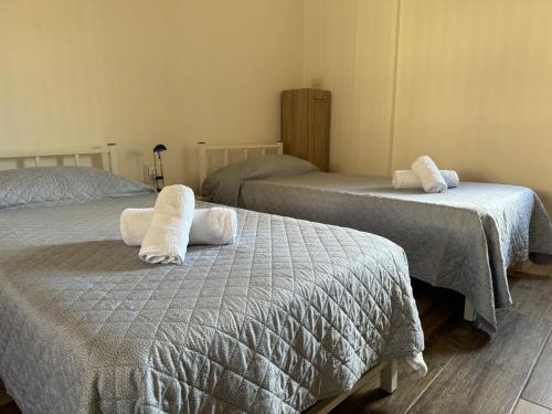 una camera da letto con due letti con asciugamani sopra di Private One Bedroom Apartment close to Airport in Luqa a Luqa