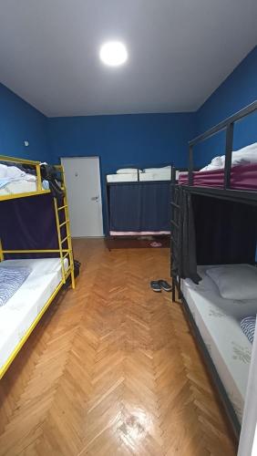 a room with three bunk beds and a wooden floor at Sky hostel in Pristina