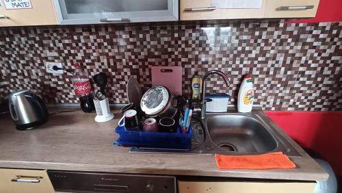 a kitchen counter with a sink with a tea pot on it at Sky hostel in Pristina