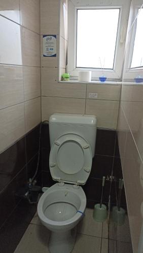 a small bathroom with a toilet with a window at Sky hostel in Pristina